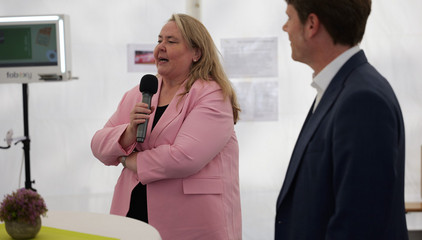 Konzerngeschäftsführerin Andrea Wichmann steht mit einem Mikrofon neben Dr. Thorsten Minuth und spricht zu den Festgästen bei der Jubiläumsfeier 20 Jahre Albertinen Services Hamburg ASH in Rellingen.